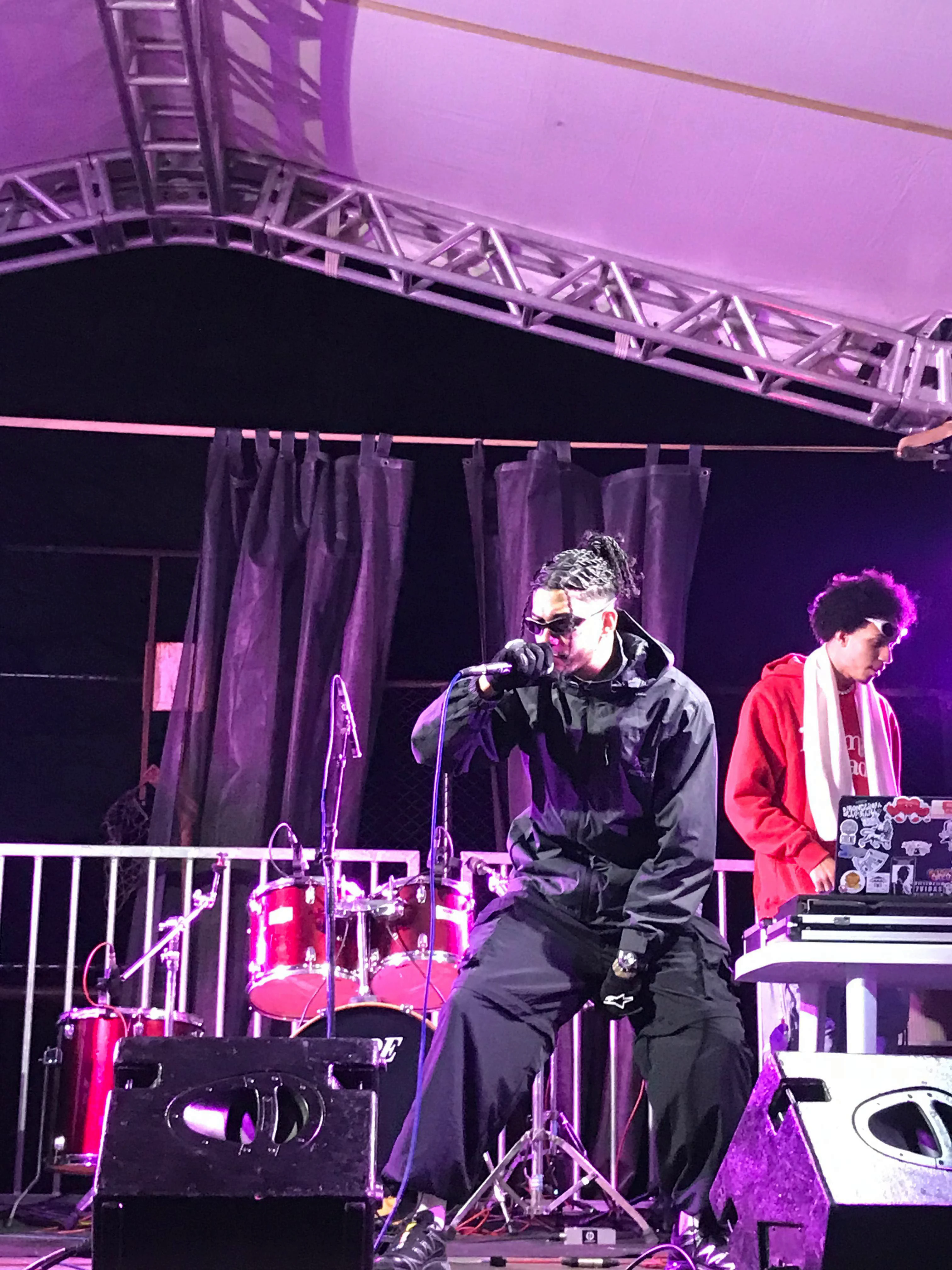 Performance sentada sob luz roxa no CEDESP Rosa Mística, 2025